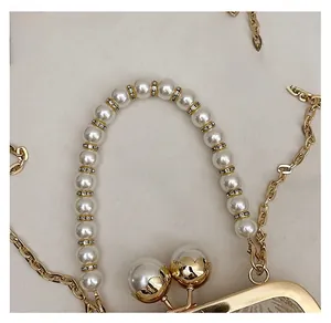 Vue détaillée de la poignée en perles avec strass et fermoir doré sur le sac coquillage