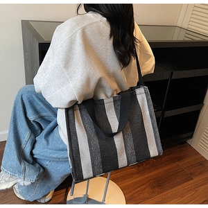 Rear view of striped canvas tote bag showing large capacity and wide shoulder strap
