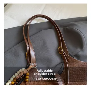 Detail of woven tote bag featuring adjustable leather strap with colorful wooden beads