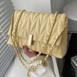 Quilted yellow crossbody chain bag with gold sphere accent and rectangular clasp detail