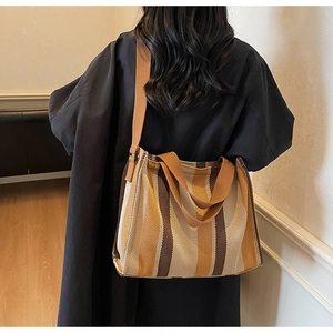 Detailed view of the striped canvas tote bag featuring wide brown and yellow stripes