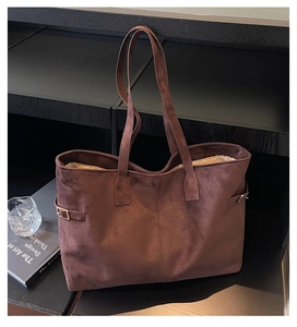 Macro shot of dark brown suede tote bag featuring side buckle and metal hardware details