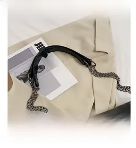 Close-up of black lychee leather strap with matte silver-tone metal chain and buckles