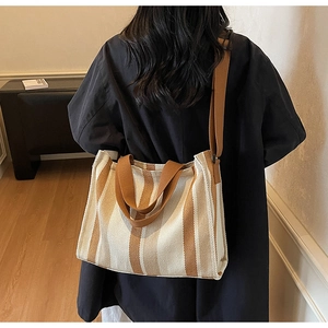 Detailed back view of a striped canvas tote bag showing the adjustable shoulder strap and size