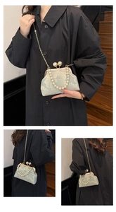 Détail d'un sac en brocart vert menthe avec broderie florale et poignée en perles