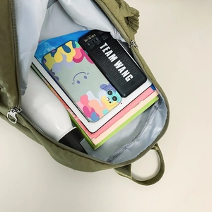 Interior view of olive green nylon backpack showing large capacity and smooth zipper