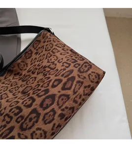Dettaglio in finta pelle scamosciata leopardata con bordo in pelle nera sulla borsa