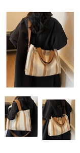 Detail of vintage striped canvas tote bag showing wide brown straps and textured fabric