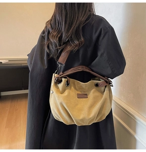 Detail of vintage canvas tote bag in mustard yellow with brown leather straps and wide belt