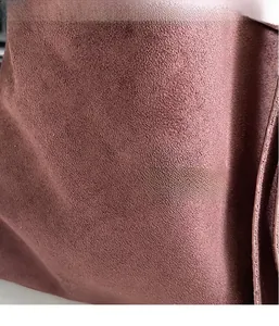 Close-up of soft faux suede fabric in dark dusty rose showing fine texture and material