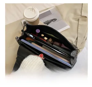 Detail view of large capacity black chain bag with multiple internal compartments