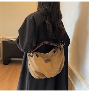 Rear view of a large vintage brown tote bag with leather handles shown on a model