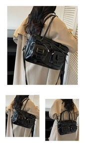 Detail of glossy black patent leather bag featuring ribbon bows and functional pockets