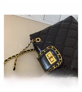 Close-up of the black quilted texture with a gold metal twist lock and chain strap detail