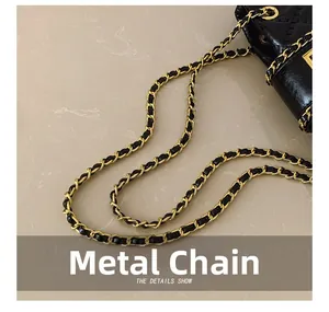 Close-up of golden hardware chain interwoven with black leather on a stylish tote bag