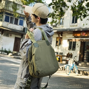 Olive green waterproof nylon backpack for women with minimalist outdoor style in city street