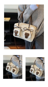 Close-up of contrast stitching and bow details on a cream faux leather shoulder bag