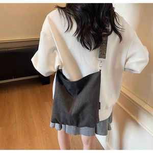 Detail of grey canvas tote bag featuring ethnic pattern wide strap and metal buckle
