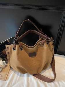 Retro khaki canvas tote bag with brown PU handles and a wide shoulder strap in room setting