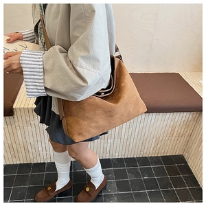 Dettaglio della borsa tote in pelle scamosciata marrone con interni capienti e tracolla