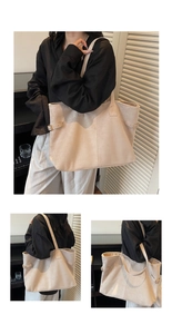 Macro detail of beige suede tote bag with metal buckles and minimalist trapezoid design