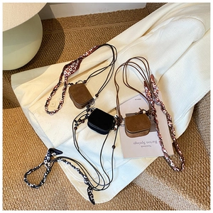 Detail of mini suede crossbody pouches with silk scarf straps and decorative beads