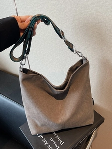 Brown canvas bucket bag with wide jacquard strap and minimalist sewing details