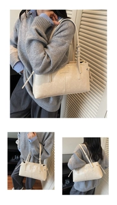 Detail view of beige leather tote bag with adjustable strap and side drawstring accents