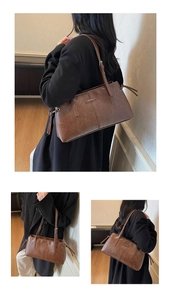 Detail view of vintage brown PU leather shoulder bag with adjustable strap and metal hardware