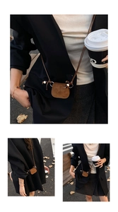 Detail of a brown suede mini crossbody bag with lanyard and decorative beads close-up