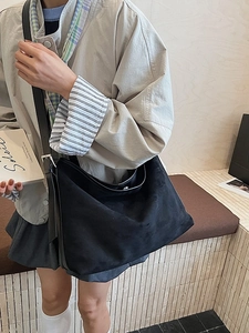 Borsa hobo minimalista in camoscio nero con grande capacità e tracolla su una modella