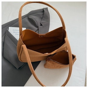 Vue détaillée de l'intérieur spacieux du cabas en daim marron avec pochette assortie