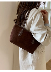 Detailed view of dark brown suede tote bag with slim shoulder straps and fine stitching