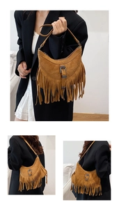 Detail of a brown suede half-moon tote bag with retro metal buckle and long tassels