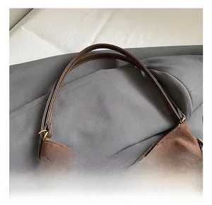 Detail of the comfortable brown suede tote bag handle with vintage gold hardware
