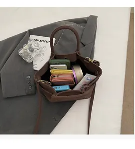 Grand sac cabas marron foncé montrant sa capacité avec téléphone et maquillage