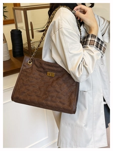 Detail of vintage quilted faux suede tote bag with gold chain strap and metal lock