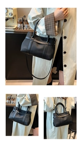 Detail view of the black textured tote with structured vertical straps and top handles
