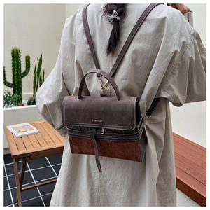 Detail of vintage brown suede stitching backpack with handle and adjustable shoulder straps
