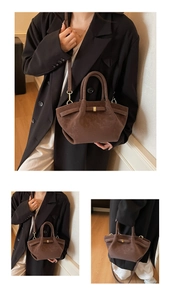 Détail d'un sac à ailes en cuir mat marron avec boucle dorée et bandoulière réglable