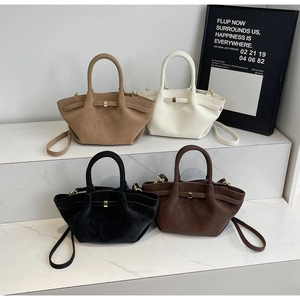 Détail de quatre sacs rétro en similicuir suédé en kaki, beige, noir et marron foncé