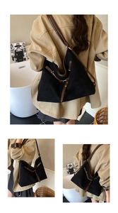 Detail of a large black suede tote bag with brown leather straps for commuting