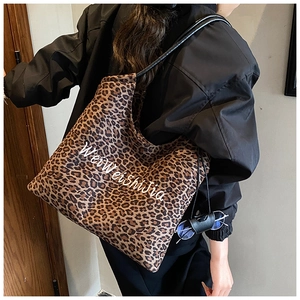 Detail of trendy leopard print tote bag showing texture and hand-written logo on shoulder strap