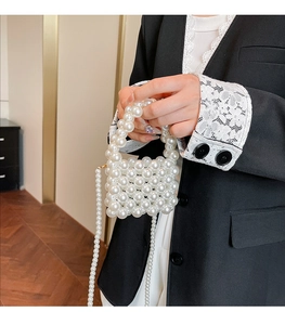 Detailed view of hand-woven pearl mini bag with elegant bead handle and strap