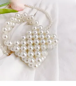 Close-up of a handmade pearl woven mini crossbody bag with glossy white beads