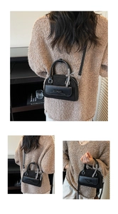 Détail d'un mini sac bowling noir avec nœud, ruban à carreaux et bandoulière réglable