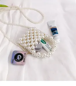 Close-up of woven pearl mini bag showing storage capacity for lip balm and cream