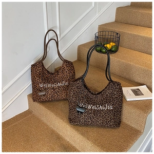 Close-up of leopard print canvas tote bags in brown and grey with plush fabric texture