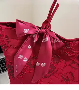 Detail der roten Hochzeits-Tote-Bag mit Spitzenstickerei und Satin-Schleife mit Xi-Zeichen