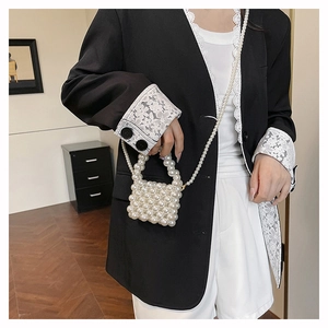 Detailed view of woven pearl crossbody bag with beaded strap and glossy white finish